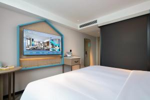 une chambre avec un grand lit et une télévision à écran plat dans l'établissement Echarm Hotel Changsha Yuelu Mountain University Town Fubuhe Subway Station Branch, à Changsha 30 autres photos
