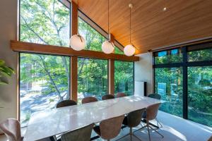 a large dining room with a white table and chairs at Hakuba Amber Echoland MrT by Jade Villa in Hakuba