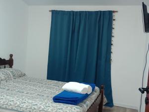 1 dormitorio con 1 cama con cortina azul en Mi Departamentito, en Federación