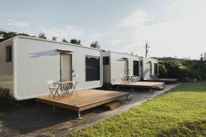 a row of three mobile homes parked in a field at Minshuku 3 by Tiny Away in Miaoli