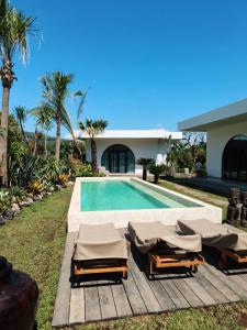 ロビナにあるVilla Cactus is far from home but like your home Villa Cactus 3 BR isn't just a tropical villa in the heart of a coconut grove it's a feeling Next door Villa Sungai also offers 2 BR and 1 Bungalow Ability to accommodate 12 peopleのラウンジチェア付きのスイミングプールが隣接しています。