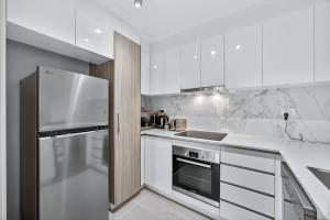 eine Küche mit weißen Schränken und einem Edelstahlkühlschrank in der Unterkunft Rockingham Corporate Retreat in Rockingham