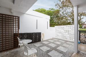 a patio with a table and chairs and a fence at De Luma-Cozy 2Bedroom Landed House, Bukit Mertajam in Bukit Mertajam