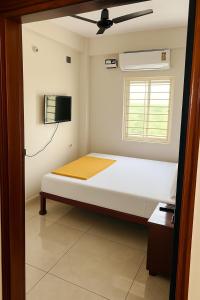 a small bedroom with a bed and a tv at Vasavi Palace Residency in Pennāttūr