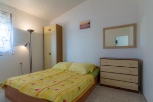 a bedroom with a bed and a dresser and a mirror at Starigrad Apartment in Starigrad