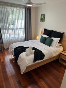 een slaapkamer met een groot bed met witte en groene kussens bij The Norgrove By Parbery Property in Kingston 