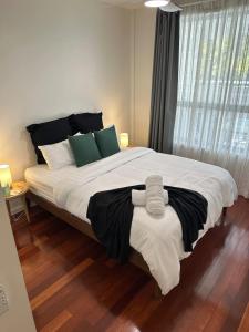 een slaapkamer met een groot bed met witte en groene kussens bij The Norgrove By Parbery Property in Kingston  +14 foto's