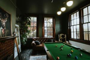 a living room with a pool table in it at Dunedin House- Boutique Hotel in Dunedin