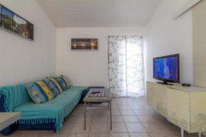 a living room with a blue couch and a tv at Starigrad Apartment in Starigrad