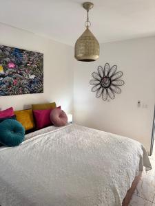 a bedroom with a bed with colorful pillows on it at Madikera Resort Beach Near in Saint-François