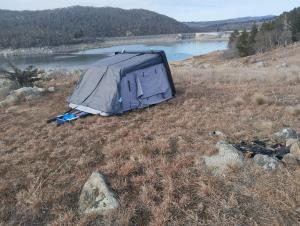 a tent sitting in a field next to a lake at Van near Jindy - Thredbo and ski areas in Jindabyne