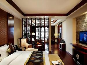 une chambre avec un grand lit et un salon dans l'établissement Jinggangshan ZhongTaiLai International Hotel, à Jinggangshanzonghekenzhichang