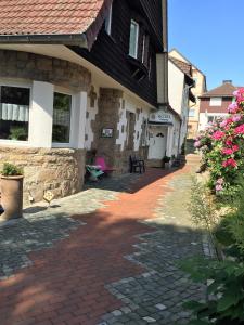 a house with a brick walkway next to a building at Hotel-Pension Teutonia in Braunlage