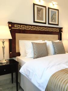 a bedroom with a white bed with a wooden headboard at Luxury Apartments MONDRIAN Market Square III in Warsaw