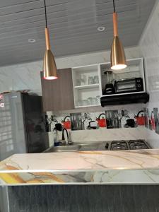 a kitchen with two pendant lights above a sink at Hermoso y acogedor Apartamento en Neiva in Neiva