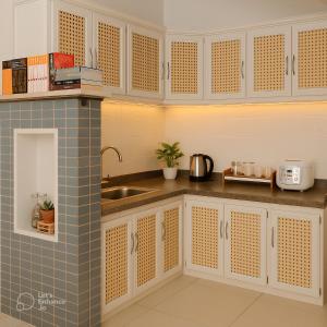 a kitchen with white cabinets and a sink at Peanuts Home Calmette - Central Saigon Homestay with Kitchen, Balcony in Ho Chi Minh City