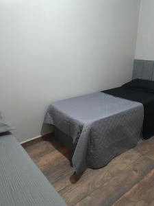 a bedroom with a bed and a wooden floor at Rancho de Pesca e Pousada Solar in Aquidavana