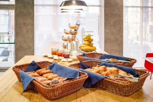 a table topped with a basket filled with donuts at ibis Chesterfield North - Barlborough in Barlborough
