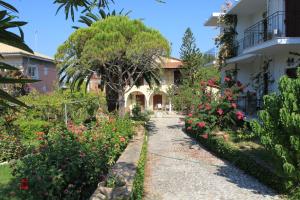 a garden in front of a house with flowers at Arillas Studios in Arillas