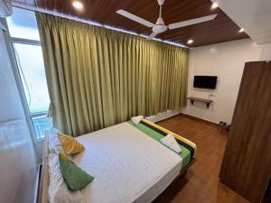 a bedroom with a bed and a window with a tv at Atithi Home Stay in Pune +8 photos