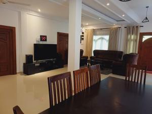 a dining room and living room with a table and chairs at JarushanInnHotel in Jaffna +40 photos
