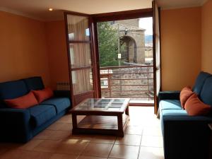 a living room with two blue couches and a coffee table at Hospedería Prepirineo in Undués-Pintano