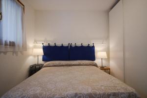 a bedroom with a bed with a blue headboard and two lamps at Cà Marin in Venice