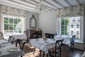 a dining room with tables and chairs and windows at The Bridge House in Ross on Wye
