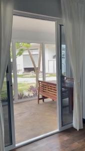 a sliding glass door leading to a patio with a bench at Bay Front Eco-Cottage in Corozal +2 photos
