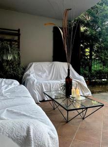 ein Raum mit einem Glastisch mit einer Vase und Kerzen in der Unterkunft Villa Atlantica B&B in Manerbio