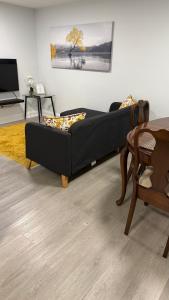 a black couch in a living room with a table at Brand new 2 bedroom basement apartment in Ajax