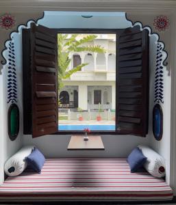 a window in a room with a table and pillows at Mahendra Prakash in Udaipur