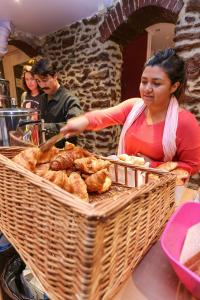 a woman is preparing food in a basket at Le Montclair Montmartre by River in Paris