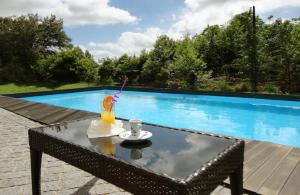 a table with a drink on it next to a swimming pool at Equinaturi in Santo Tirso