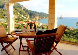 mesa de comedor con vistas al océano en Lido Paradise Apartments Corfu, en Agios Gordios