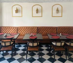 a dining room with tables and chairs and a bench at Mahendra Prakash in Udaipur