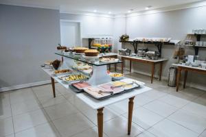a table with several trays of food on it at Diamond Hotel in Rio de Janeiro