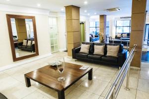 Diamond Hotel في ريو دي جانيرو: غرفة معيشة مع أريكة وطاولة