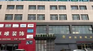 een groot gebouw met borden aan de zijkant bij Green Tree Inn Liaoning Shenfu New District in Mantangmanzuxiang +10 foto's