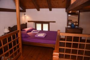 a bedroom with a bed with purple sheets and a mirror at erofili apartments in Kalamos