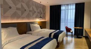 Postel nebo postele na pokoji v ubytování Borrman Hotel Shaoguan Nanxiong Rt-Mart