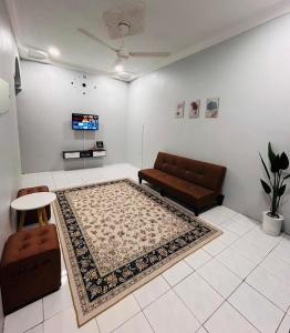 una sala de estar con un sofá y una alfombra en Anuarosi Homestay Taman Melor, Teluk Intan, en Teluk Intan