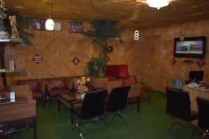 a living room with a couch and chairs and a tv at Hotel Raj Palace in Rishīkesh