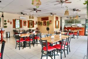 um restaurante com mesas de madeira e cadeiras vermelhas em Hotel Yorio Inn em Tuxpan de Rodríguez Cano