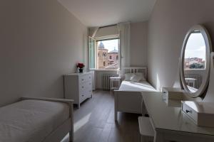 a bedroom with two beds and a desk and a mirror at St. Vitale’s Basilic view elegant apartment in Ravenna