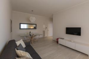 a living room with a couch and a tv on a wall at St. Vitale’s Basilic view elegant apartment in Ravenna