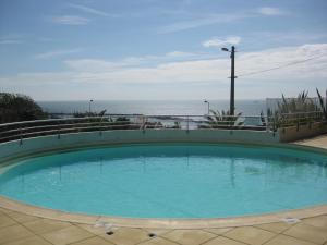 a swimming pool with the ocean in the background at Sète - vue mer imprenable, piscine, calme in Sète
