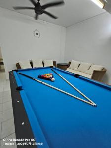 a pool table with two cuesticks on top of it at TANGKAK HOMESTAy in Tangkak +6 photos