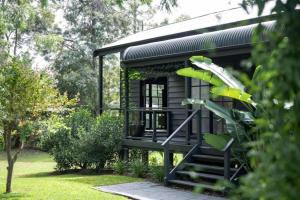 a black tiny house with stairs in a garden at Eune House in Broke