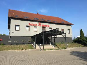a large white building with a red roof at Zajazd Pod Borem in Pokój